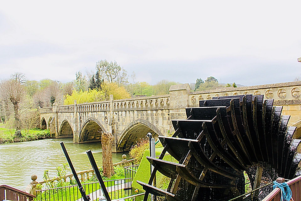 Historic water wheel and stone bridge beside Il Mulino